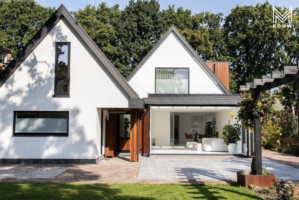 Achtergevel met twee puntgevels en de nieuwe uitbouw met glazen pui